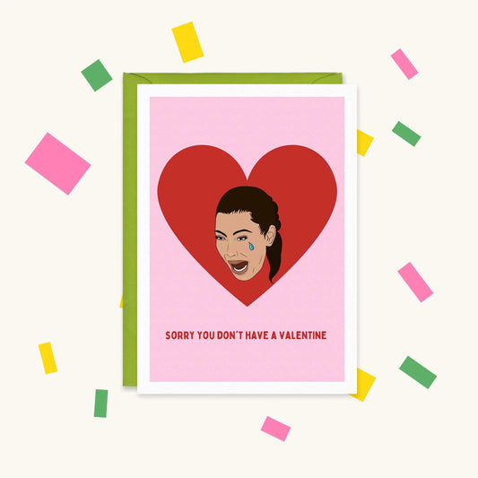 Greeting card of crying Kim Kardashian in a red heart on pink, reading "Sorry you don't have a Valentine"
