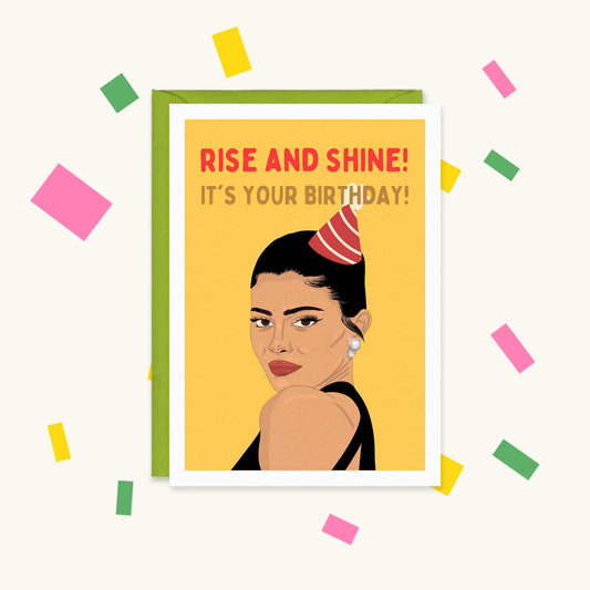 Greeting card of Kylie Jenner in a party hat on yellow, reading "Rise and shine! It's your birthday!"