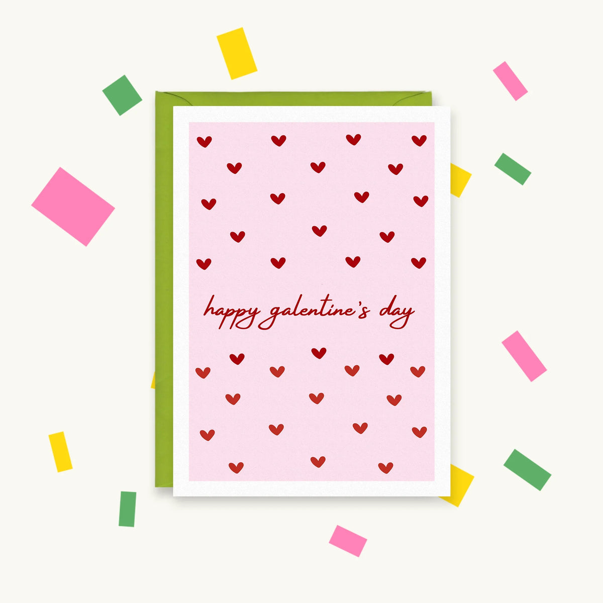 Greeting card with small red hearts on a pink background and script text "happy galentine's day"