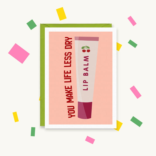 Greeting card with a cherry lip balm tube on a peach background and the words "You make life less dry"