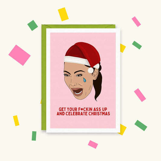 Greeting card of crying Kim Kardashian in a Santa hat on pink, reading "Get your f#ckin ass up and celebrate Christmas"