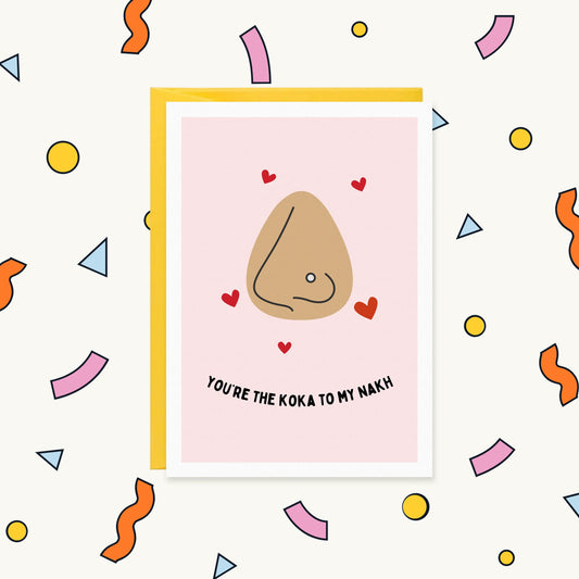 Greeting card with a nose wearing a nose stud surrounded by red hearts on pink, reading "You're the koka to my nakh"